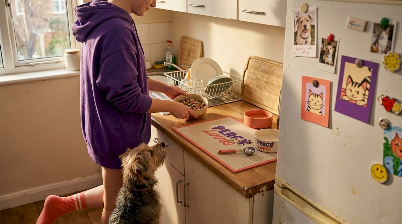 Preparing pet food in kitchen with dog