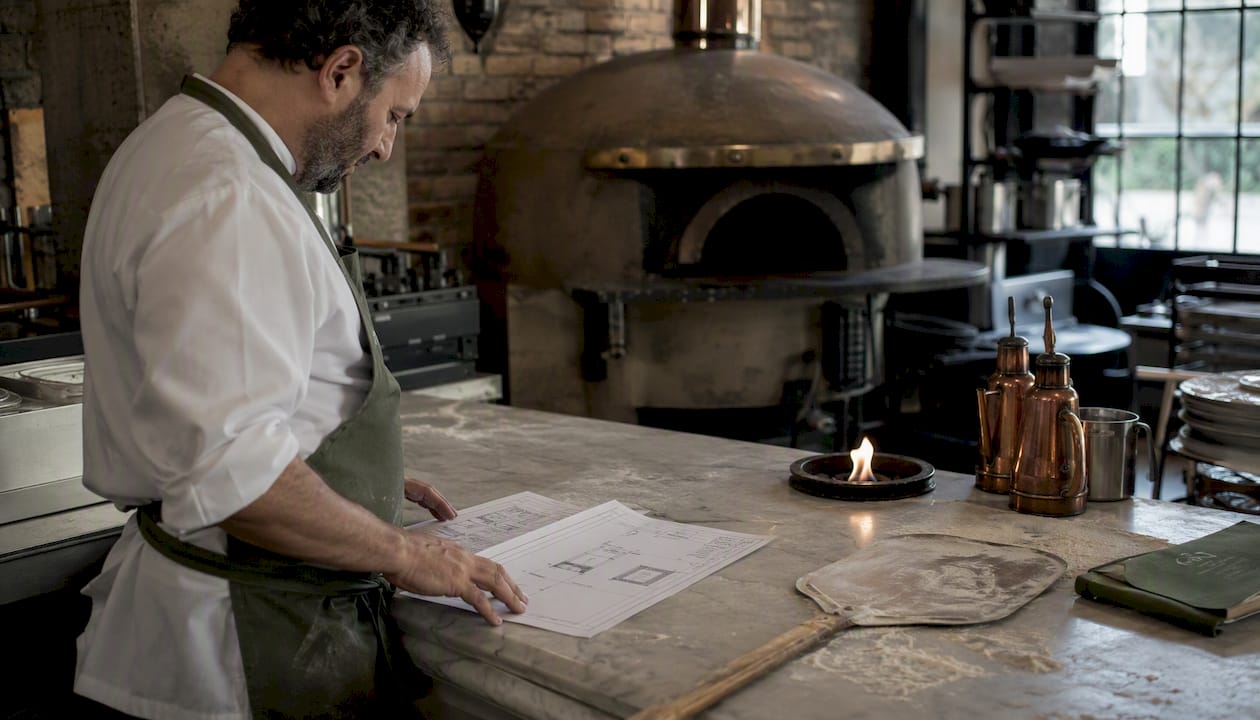 Chef examining pizza oven hood specifications