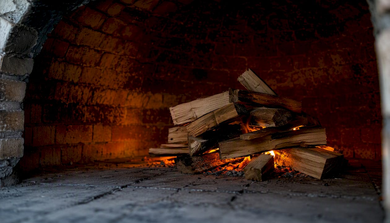 Small curing fire inside pizza oven hearth