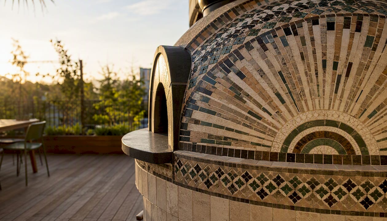 Radial mosaic tile pattern on pizza oven dome