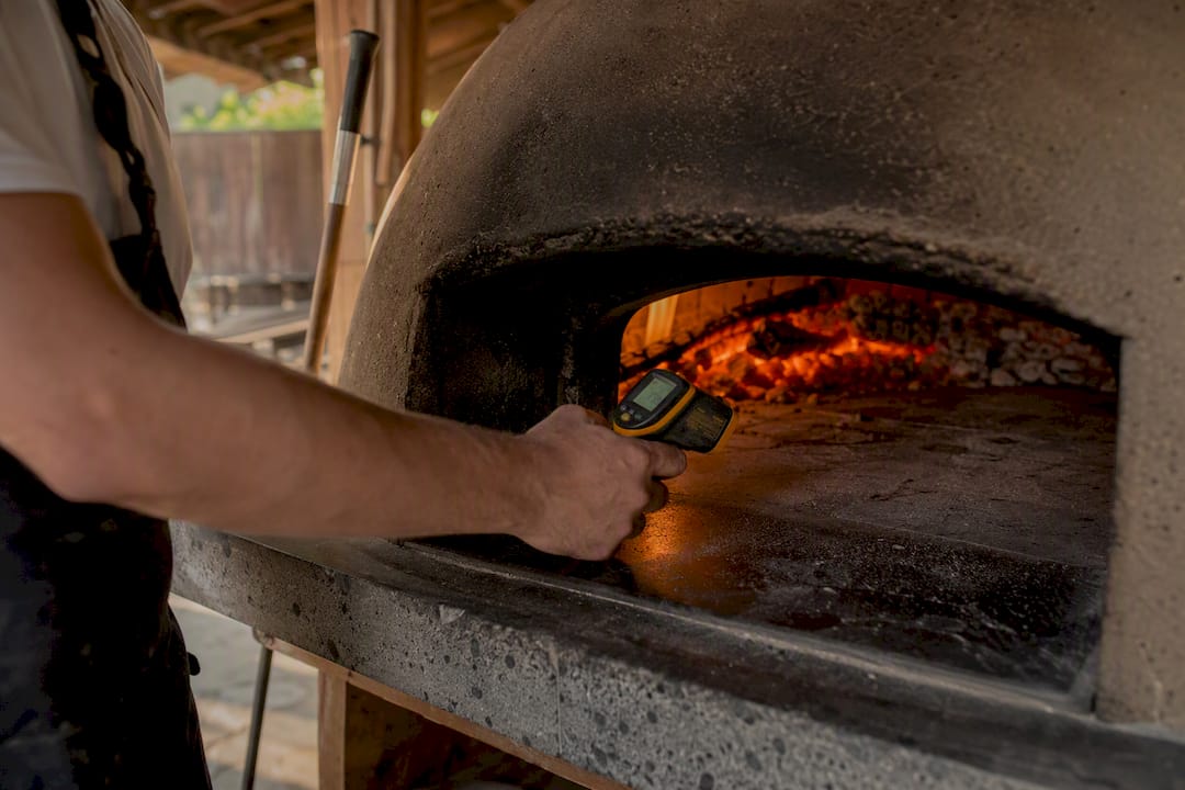 Termometro a infrarossi che misura la pietra del forno per pizza