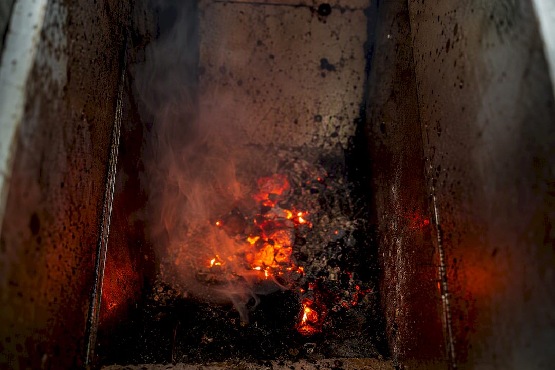 Smoke and embers inside pizza oven grease duct