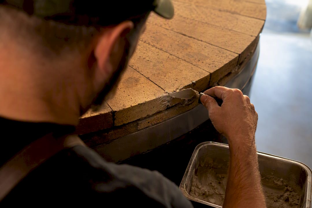 Albañil reparando una junta de horno refractario