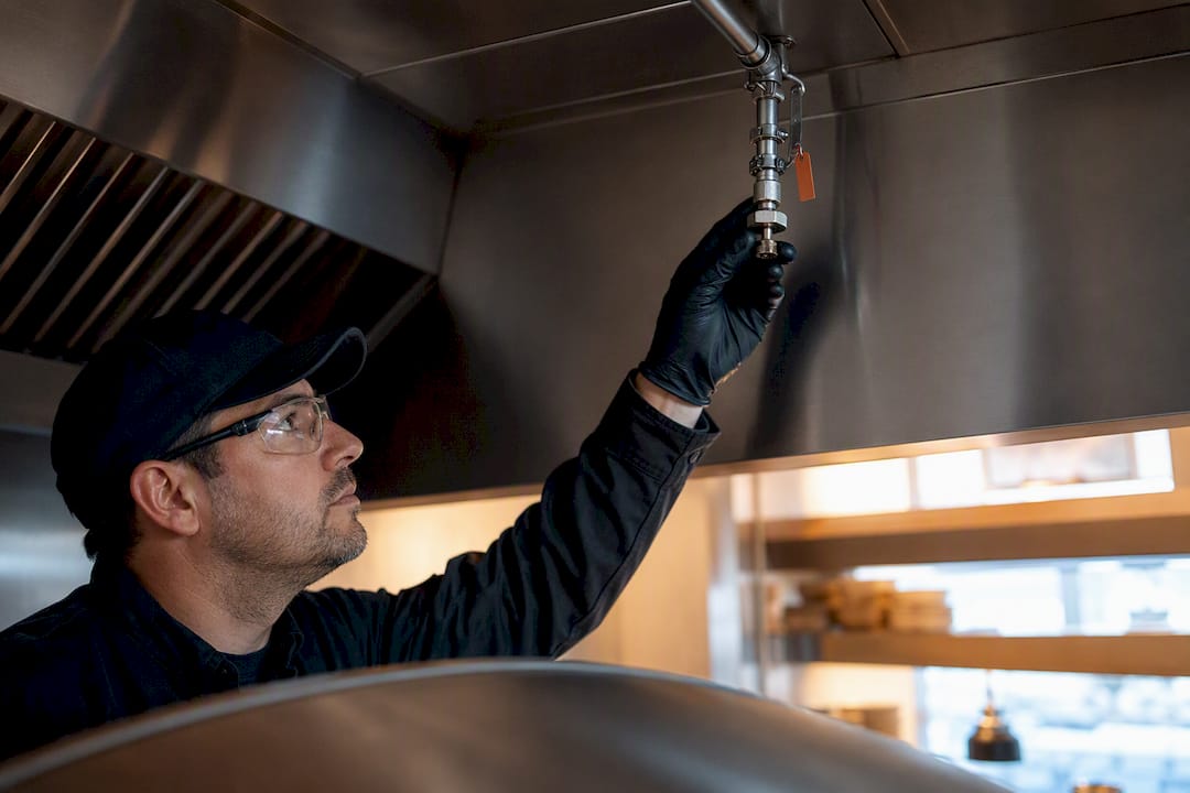 Technician checking pizza oven suppression nozzle