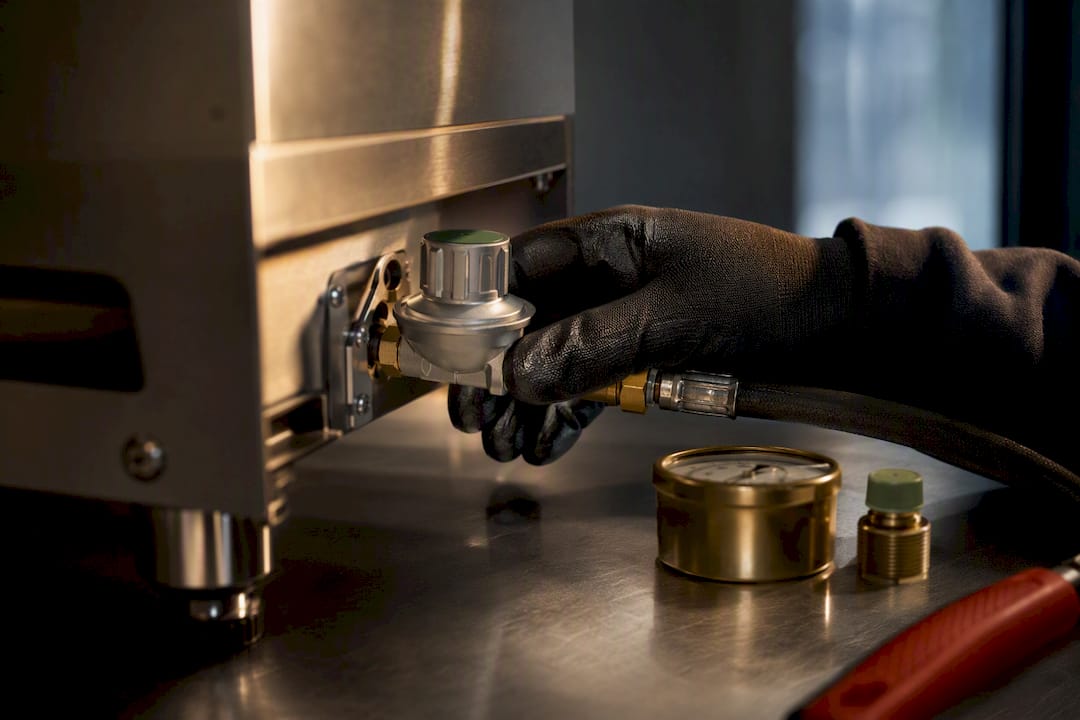 Installateur überprüft Gasdruckregleranschluss am Ofen