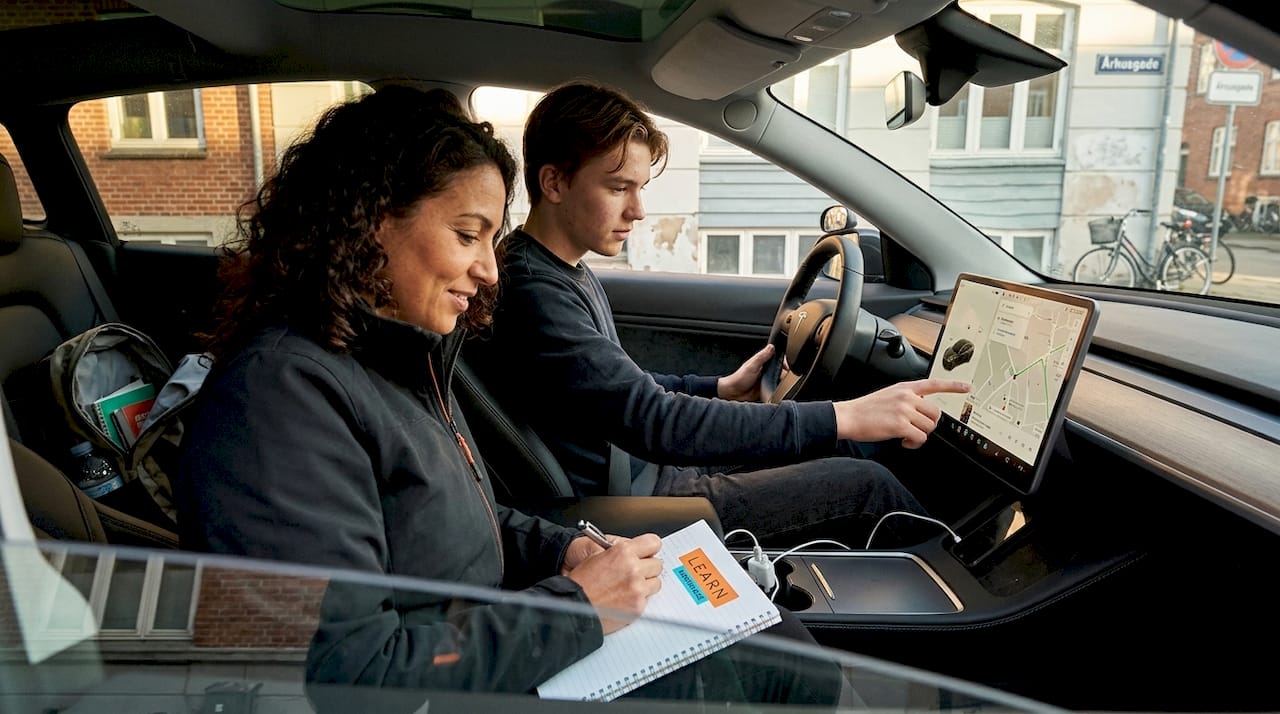 En ung elev lærer at køre elbil midt i Aarhus