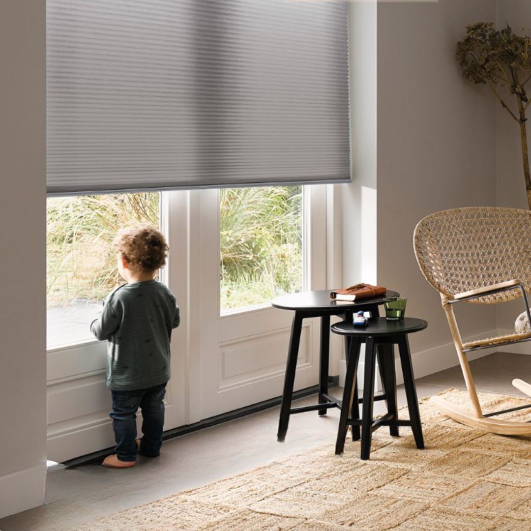 Family enjoying sunlit living room with honeycomb blinds