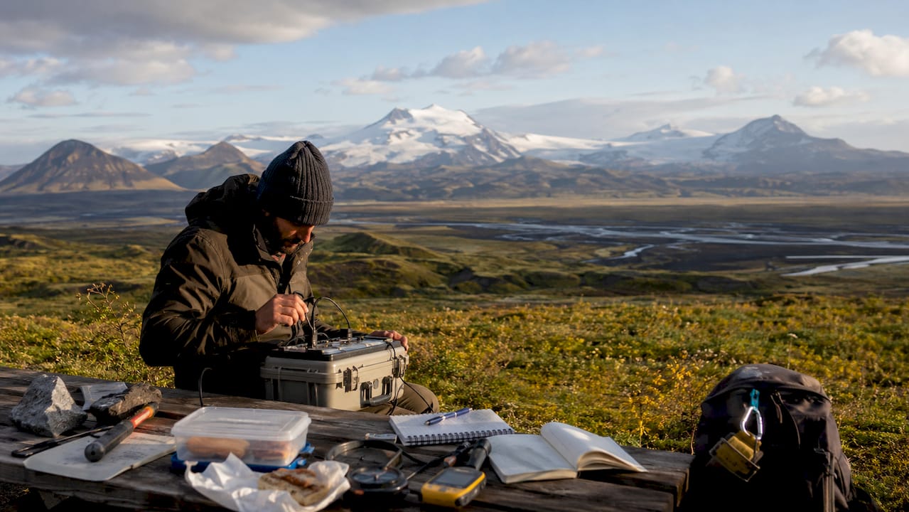 Field scientist studying Iceland volcanoes with instruments