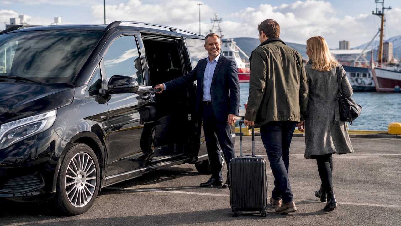 Driver opening van door for passengers at airport