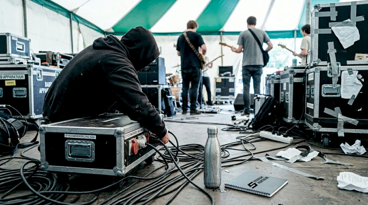 Achter de schermen op het festival zorgt de technicus ervoor dat de stroom goed verdeeld wordt naar alle apparatuur.