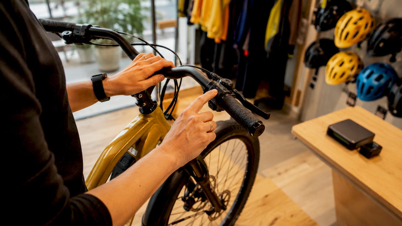 Detailopname van een fietser die het GPS-beveiligingssysteem van zijn e-bike instelt