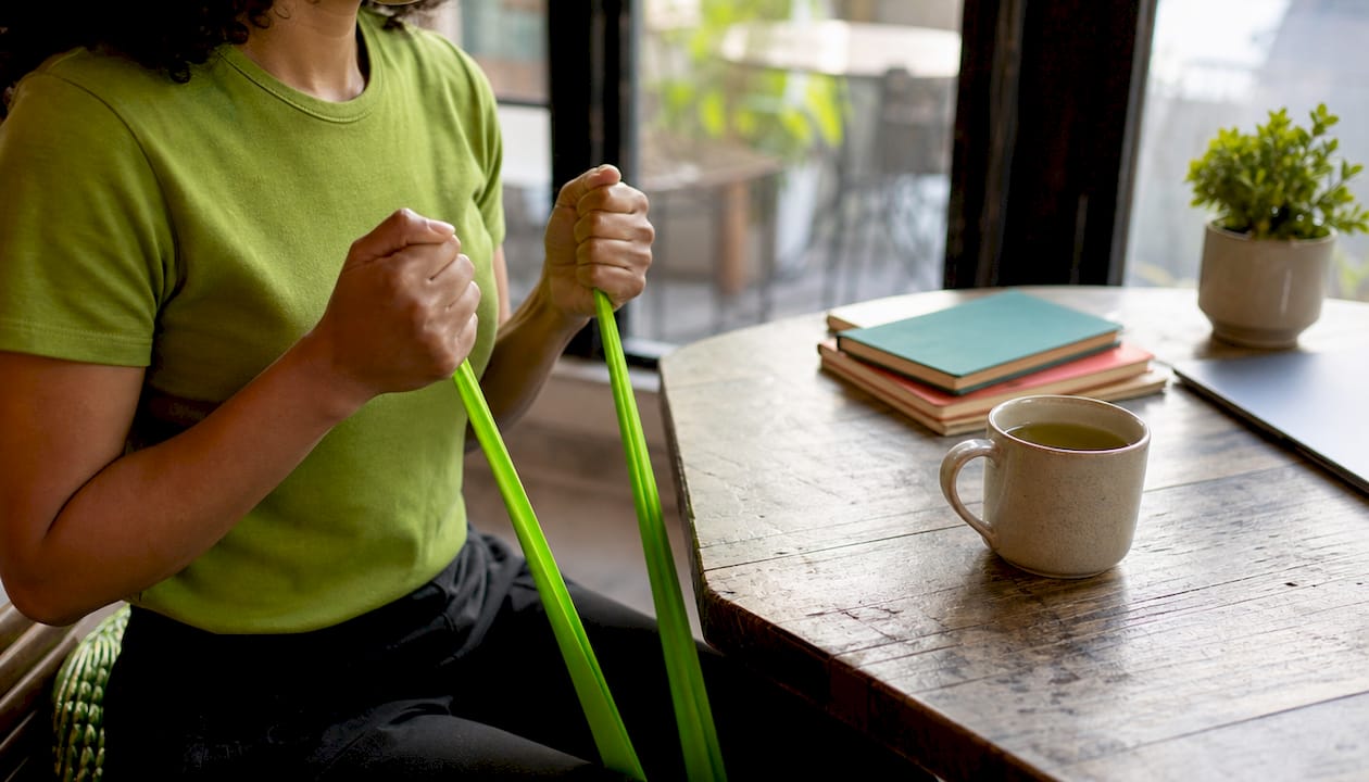 Hands doing resistance band desk exercises