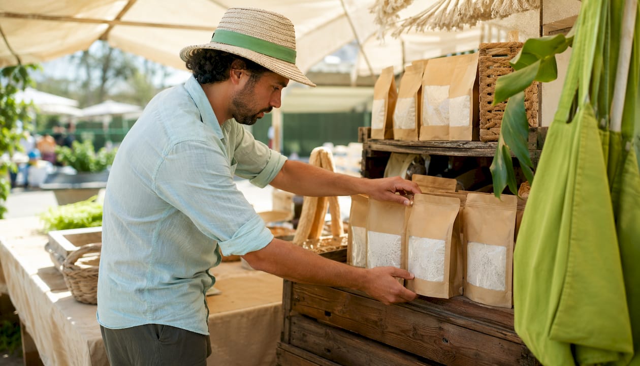Shopkeeper arranging organic gluten free flour packages on shelves