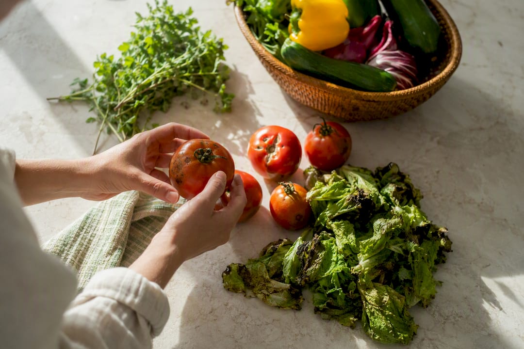 Hands inspecting damaged vegetables after delivery