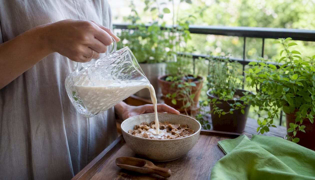 Pouring fortified plant milk into cereal bowl