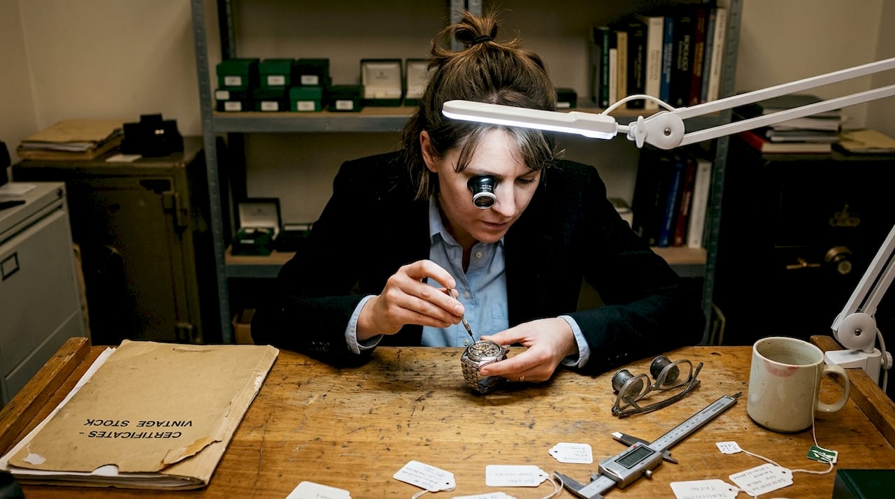 Specialist authenticates Swiss watch at workbench