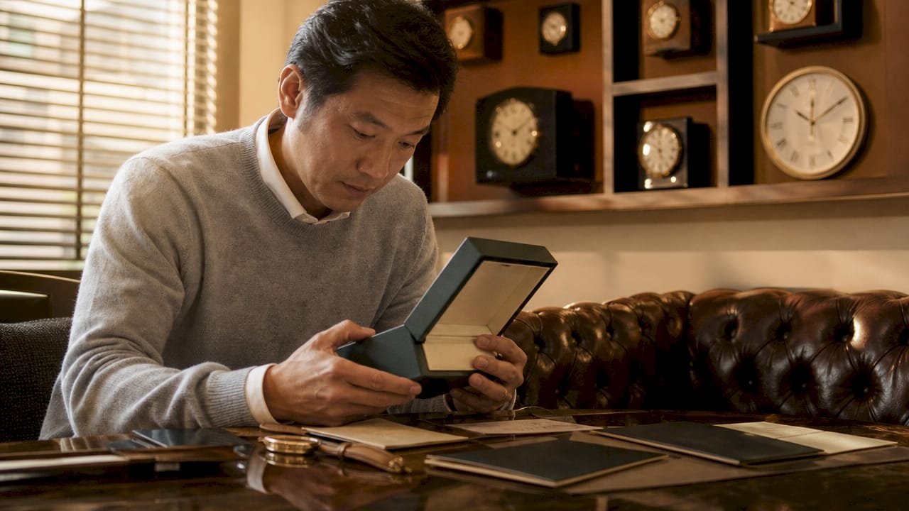 Collector inspecting watch box and papers at desk
