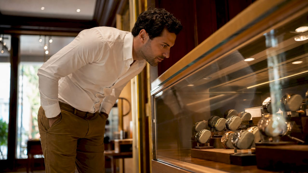 Man browsing mid-tier watch brands in boutique