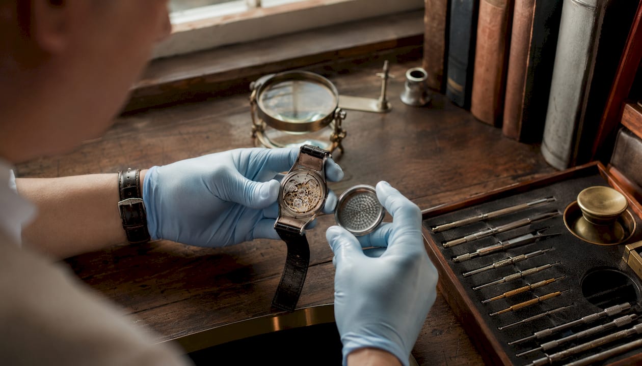 Watchmaker inspecting Omega watch reference numbers