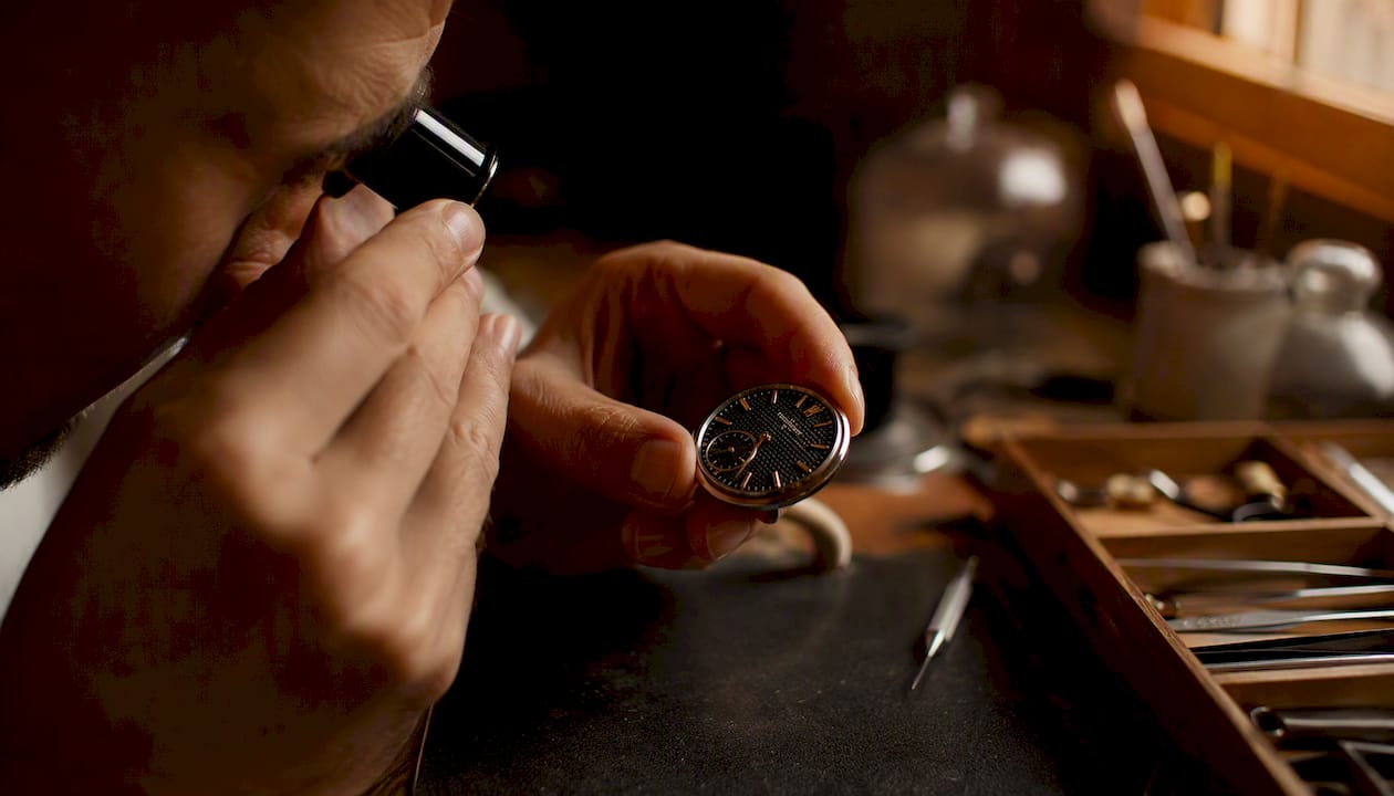 Hands closely inspecting luxury watch dial