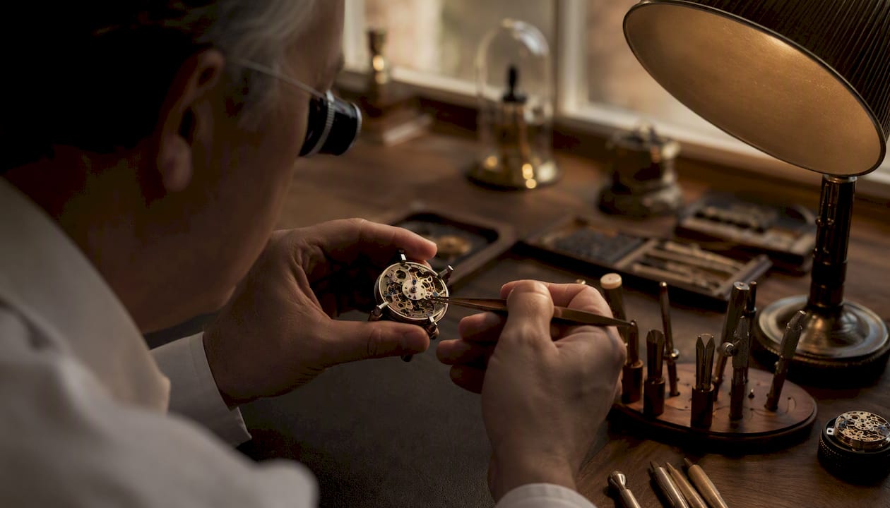 Watchmaker hands assembling watch gears close-up