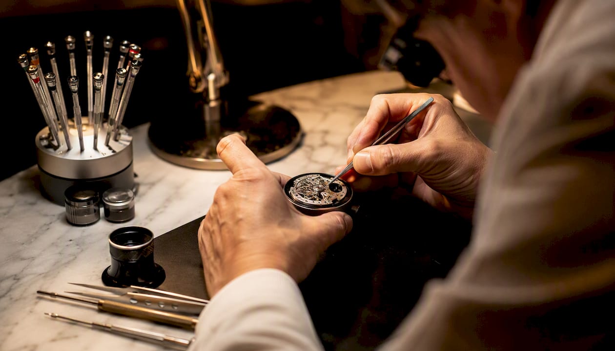 Watchmaker hands servicing luxury watch