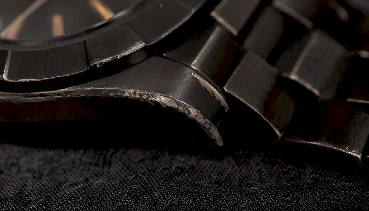 Worn edges of black coated watch case