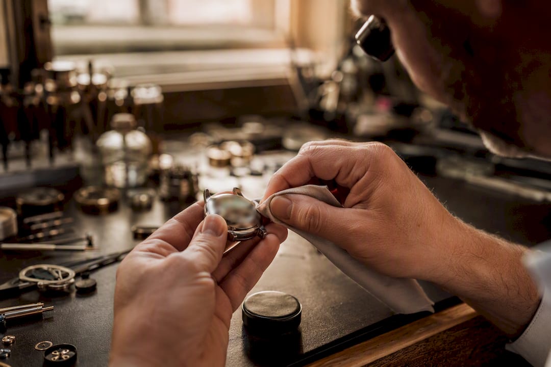 Close-up of hands polishing watch case