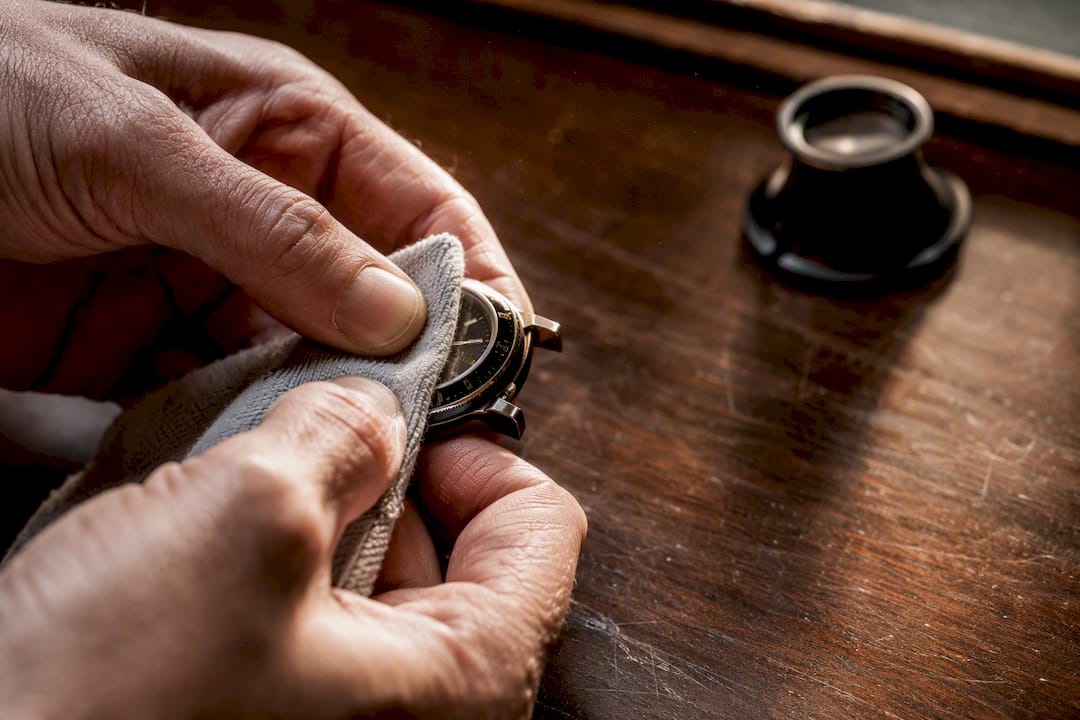 Hands cleaning luxury watch bezel gently