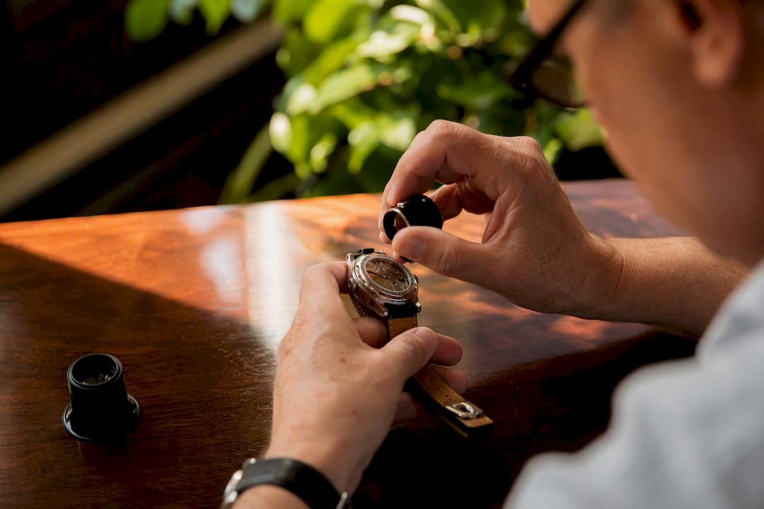 Hands inspecting serial number on watch case