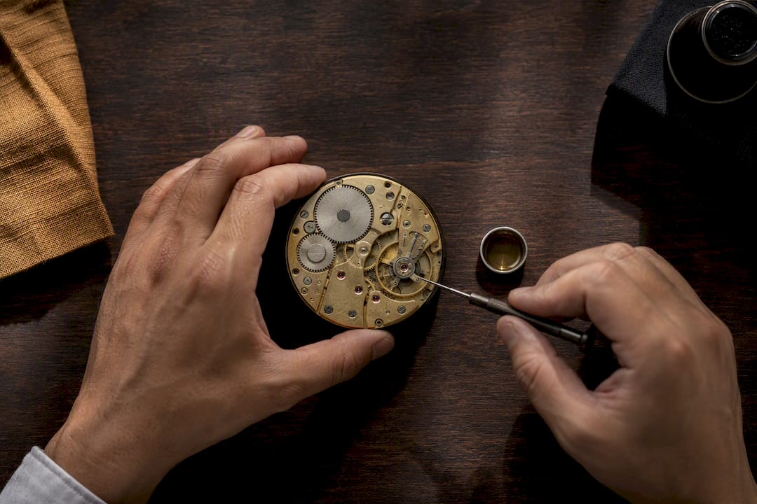 Partially disassembled watch movement on service bench