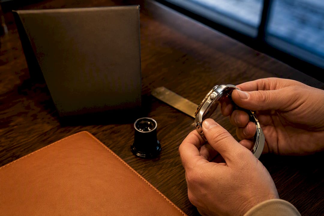Appraiser comparing watch and insurance valuation