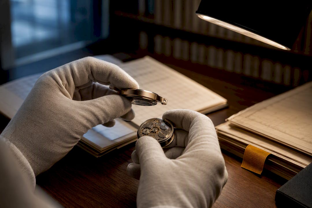 Hands examining vintage watch archival records