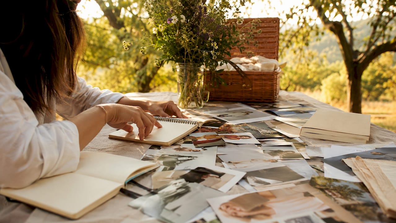 Mão a escolher e a organizar imagens para criar um moodboard de inspiração de moda