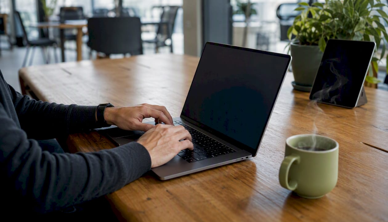 Hands holding smartphone over desk with brand colors