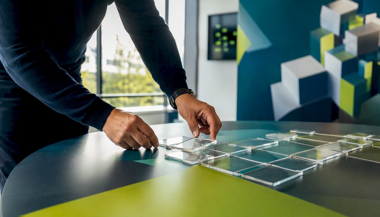 Hands arranging workflow tiles in an operations room