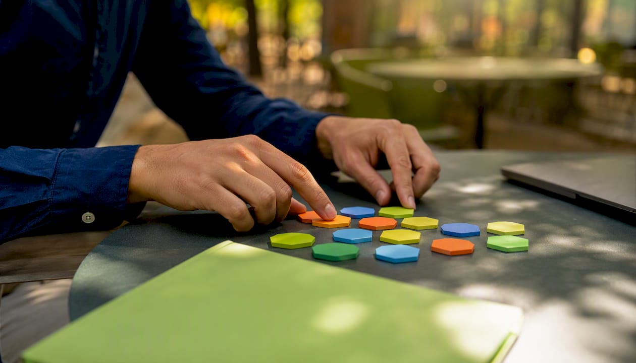 Hands sorting prospect tokens on desk