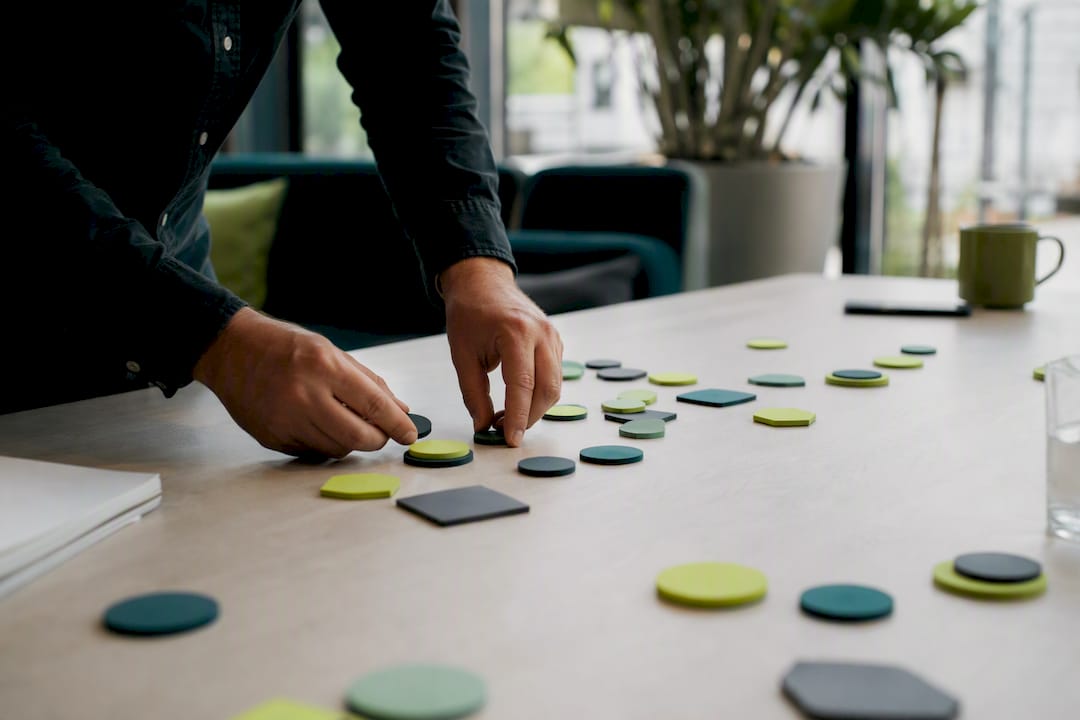 Hands sorting sales lead tokens on desk