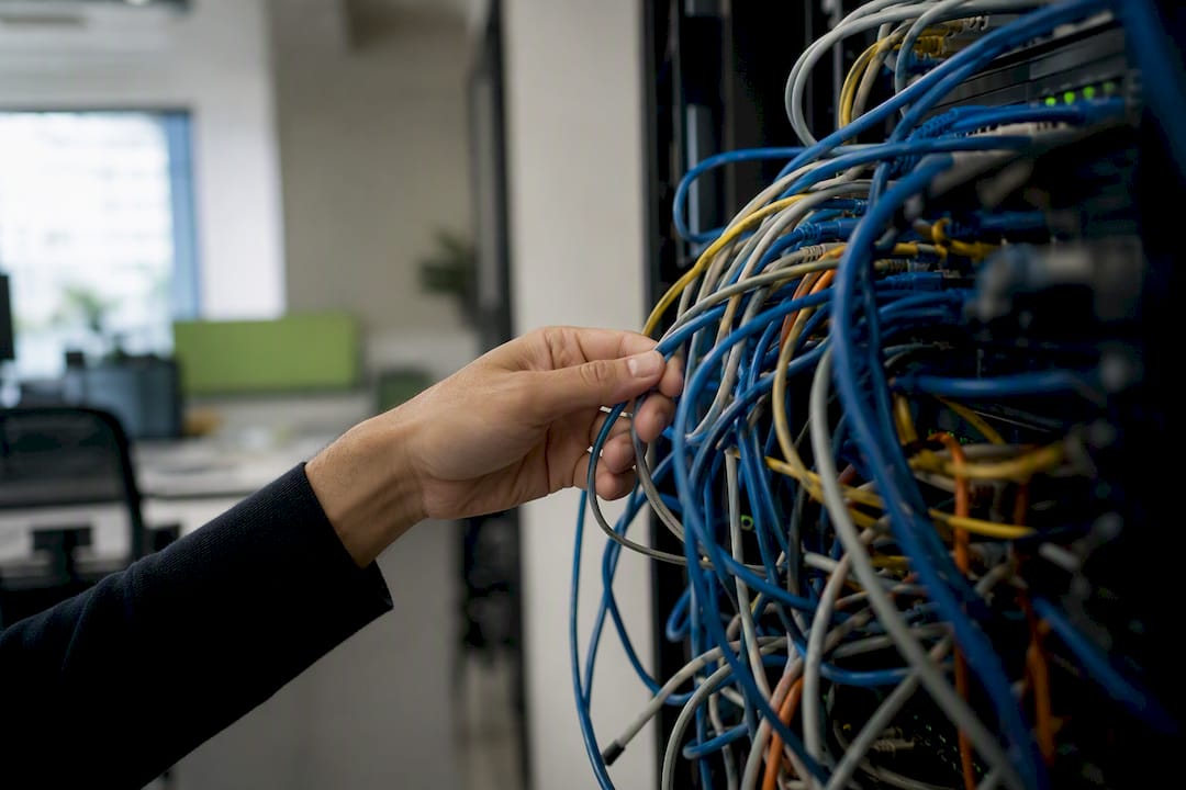 Hand inspecting network cables in office