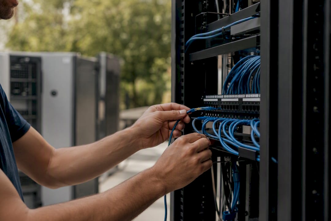 Hands connecting network cable in server rack