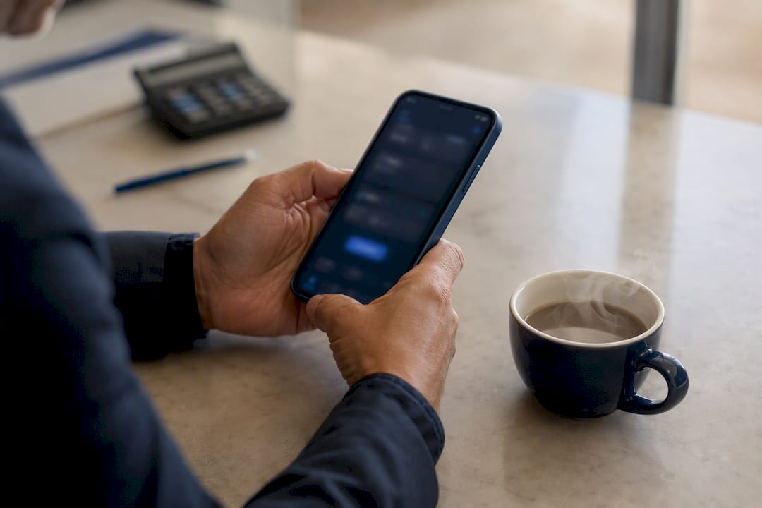 Mãos a segurar um smartphone com gráficos de empréstimos
