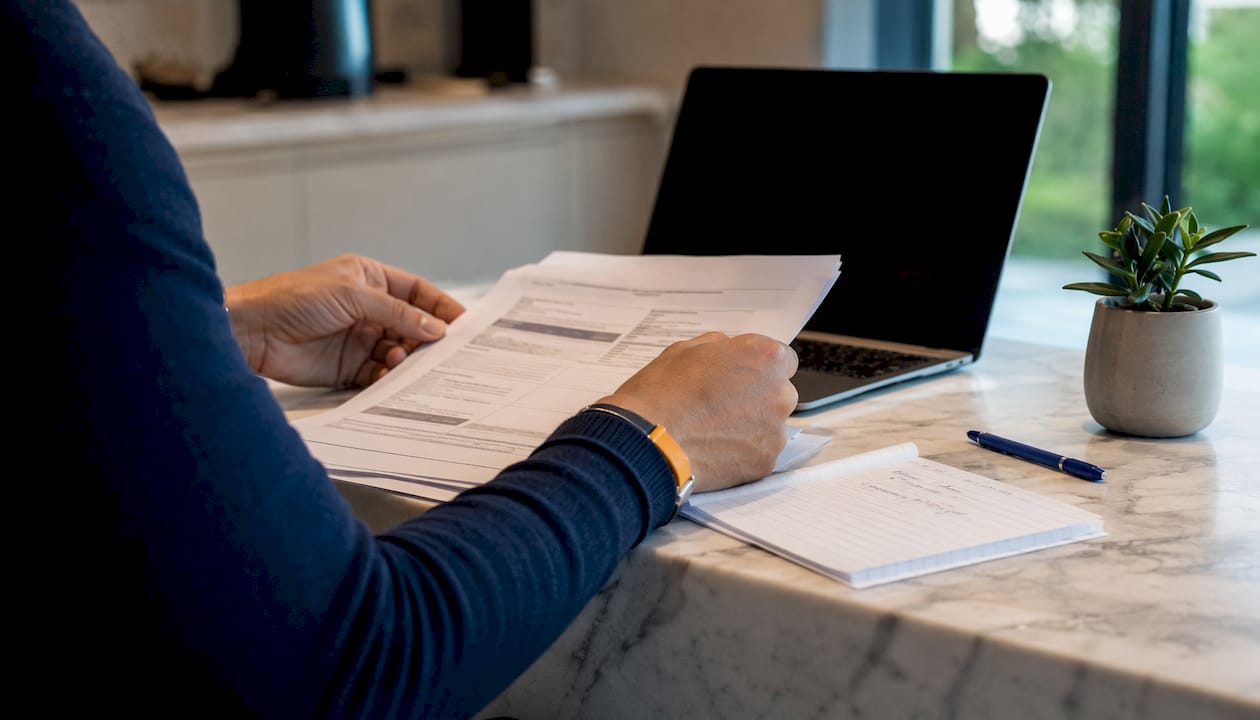 Hands holding car finance documents on desk
