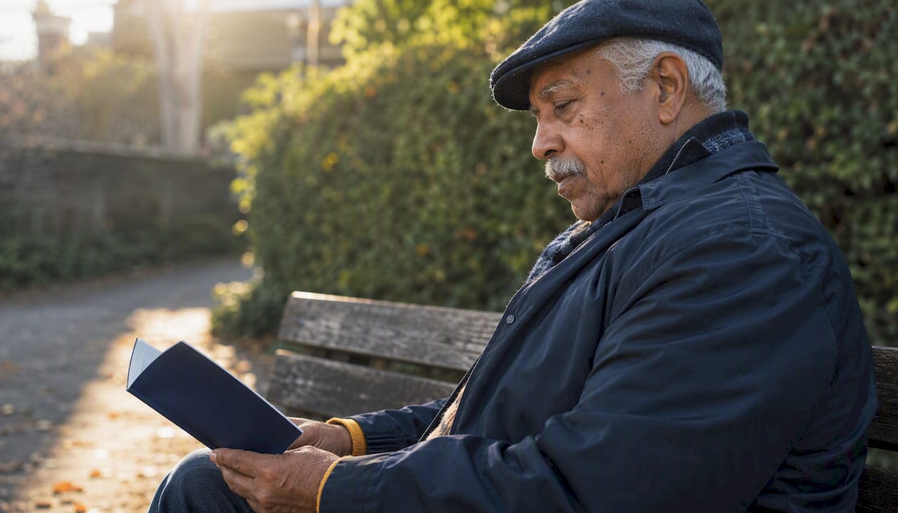 Senior man reading consumer rights booklet outdoors