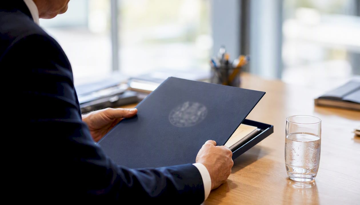 Hands inspecting financial documents with magnifying glass