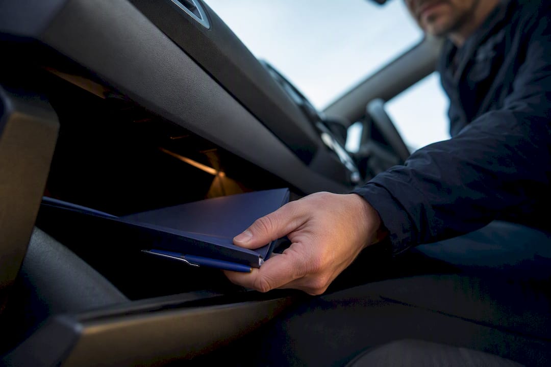 Driver retrieving car finance agreement folder