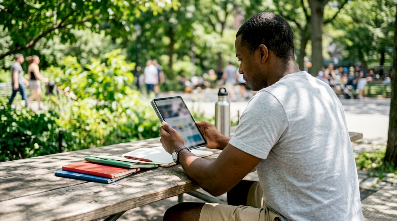 Hands holding tablet showing mobile website layout