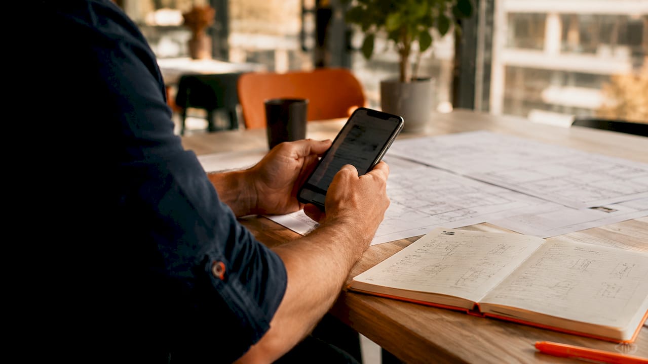 Hands sending construction meeting agenda via phone
