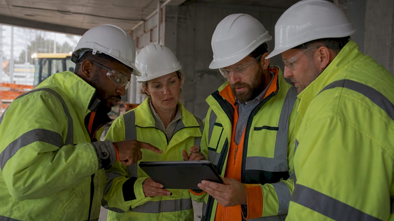 Construction team reviewing AI action items on tablet outdoors