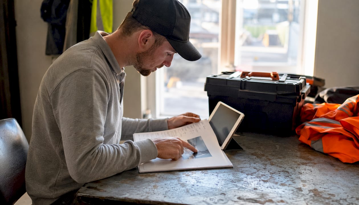 Builder comparing paper checklist and digital app