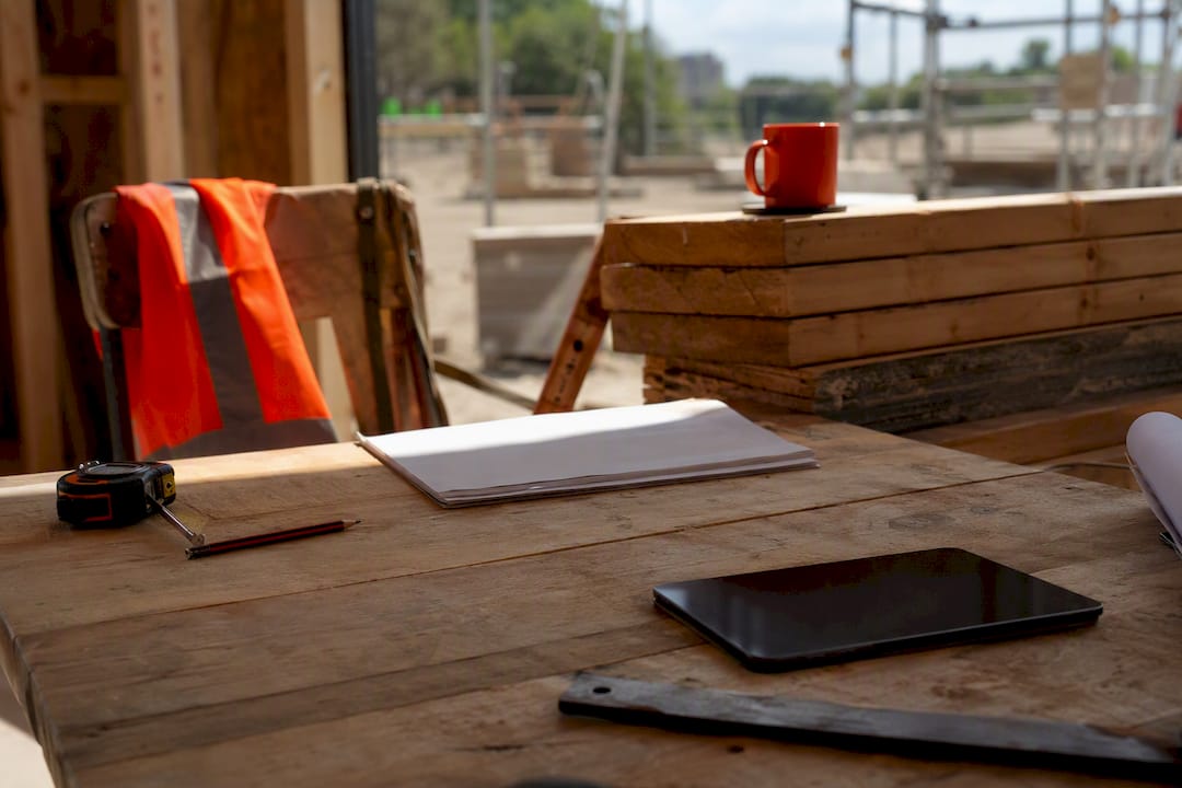 Construction site desk with tools and dark tablet